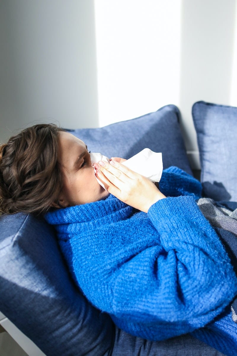 Woman in Blue Sweater Lying on Bed